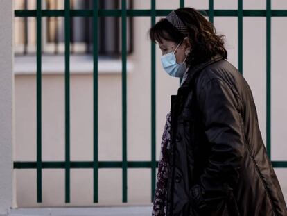 Una mujer con mascarilla camina en una calle de Madrid. 