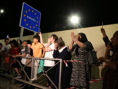 Varias personas apostadas junto a la frontera del Tarajal, en el lado español del límite entre España y Marruecos, la noche de este lunes.
