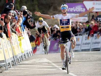 Evenepoel alza los brazos antes de cruzar la línea de meta de La Molina por delante de Roglic.