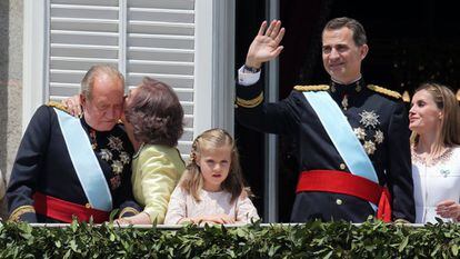 La reina Sofía besa al rey Juan Carlos en el balcón del palacio Real de Madrid, mientras el rey Felipe saluda al público congregado en la plaza de Oriente, junto a la princesa Leonor y la reina Letizia tras la proclamación del rey Felipe VI, el 19 de junio de 2014.