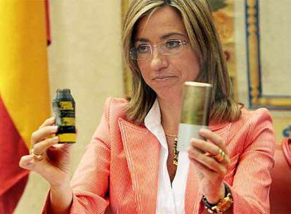 La ministra de Defensa, Carme Chacón, muestra una bomba de racimo en el Congreso.