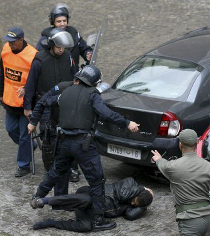 Agentes patean a un manifestante en una calle de Casablanca. La policía ha reprimido hoy duramente en la ciudad marroquí las protestas del movimiento <i>20 de febrero</i>, las primeras manifestaciones celebradas tras el discurso, el pasado miércoles, en que Mohamed VI prometió una reforma constitucional.