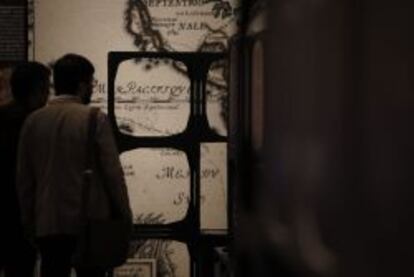 Dos hombres observan material de la exposición 'Diseñar América: El trazado español de los Estados Unidos' en la Biblioteca Nacional.