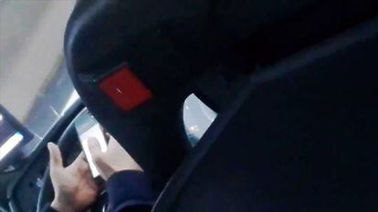 Un conductor fent servir el mòbil al volant.
