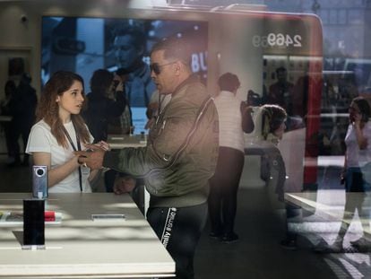 Una treballadora a la nova botiga Huawei de Barcelona atén un client.