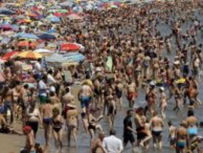 Los ba&ntilde;istas abarrotan la Playa de la Malvarrosa en Valencia. 