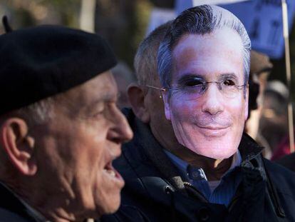 Un hombre protesta por el juicio a Garzón junto a otro con una careta con el rostro del juez esta mañana frente al Supremo