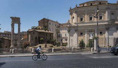 Un ciclista en una carretera en mal estado en el centro histórico de la capital italiana.