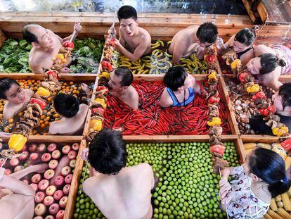 Varias personas disfrutan de un baño en una piscina de aguas termales con forma de olla en un hotel en Hangzhou.