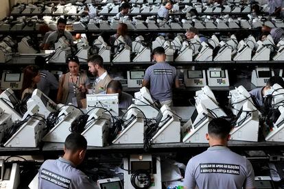 Empleados del Tribunal Electoral sellan las urnas electrónicas en septiembre de 2022, un mes antes de las presidenciales.