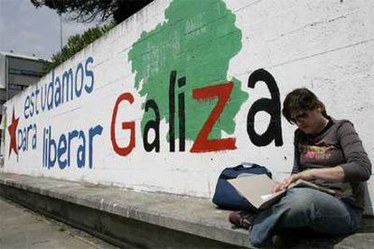 Una estudiante, al lado de una pintada nacionalista en el campus de Santiago de Compostela.
