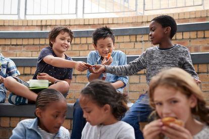 Varios niños en un colegio comparten el almuerzo.