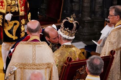 El príncipe de Gales besa a Carlos III tras ser coronado. Instantes antes, el príncipe Guillermo se ha arrodillado antes su padre para jurarle lealtad y fidelidad en el histórico juramento de sangre durante la coronación.