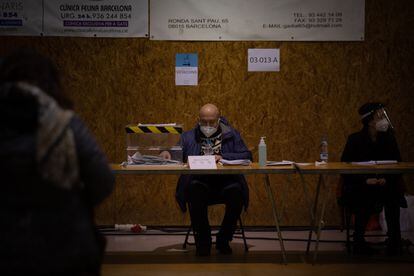 Un hombre en una mesa electoral en el Polideportivo Tres Xemeneies, en Barcelona.