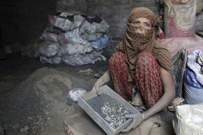 Una mujer criba materiales que serán mezclados con fertilizando en Kamrangirchar (Bangladesh).