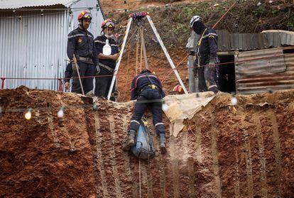 Integrantes de los equipos de rescate en el pozo excavado.