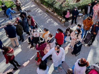 Varias personas hacen cola para recibir alimentos de la Fundación Madrina, en Madrid.