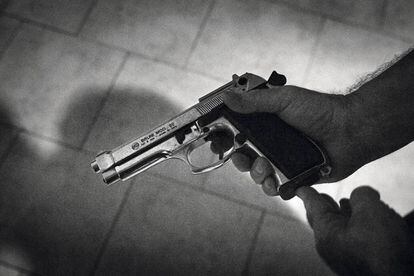 El padre de uno de los chicos de una banda muestra la pistola con la que duerme en la mesita de noche.