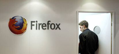 Un hombre junto a un logo de Firefox.