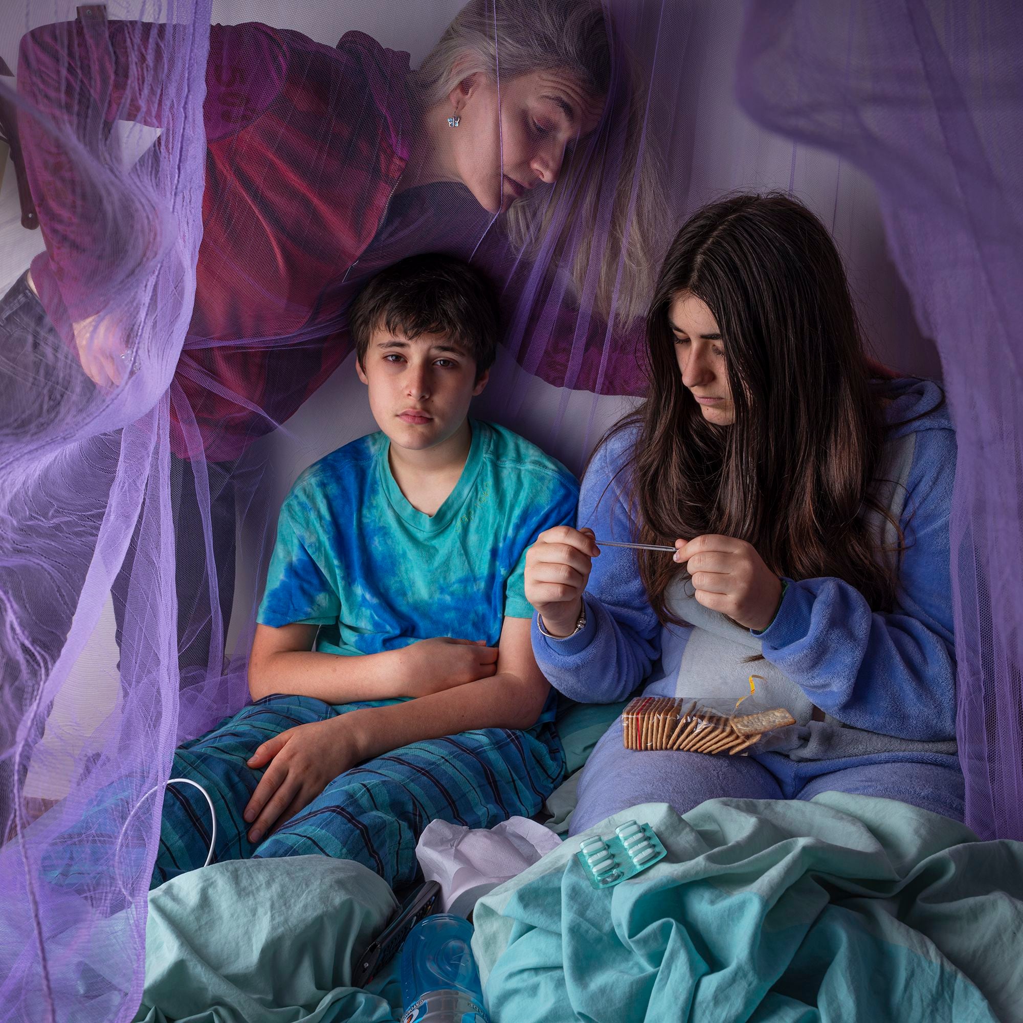Lara, 15, and Milo, 13, in bed with dengue fever in Buenos Aires, Argentina, with their mother Verónica.  Only 1 in 5 people infected with dengue have symptoms.  Symptoms may include: high fever, severe headache, pain behind the eyes, muscle and joint pain, nausea, vomiting and skin rashes.  People infected a second time have a higher risk of severe dengue fever.