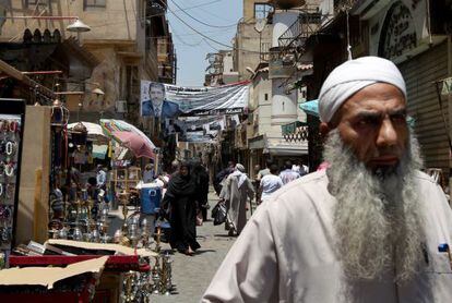 Un hombre pasea por una calle donde cuelga un cartel a favor del candidato de los Hermanos Musulmanes, Mohamed Mursi.