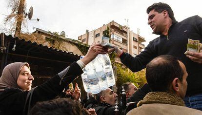Un hombre vende botellas de agua mineral en un barrio de Damasco.