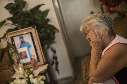 María del Transito llora frente a una foto de su hijo y su nieto en el interior de su vivienda.