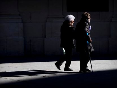 Dos mujeres mayores caminan cogidas del brazo este viernes en Sevilla. PACO PUENTES (EL PAÍS).