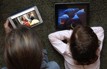 Dos personas ven series de televisión en tabletas.