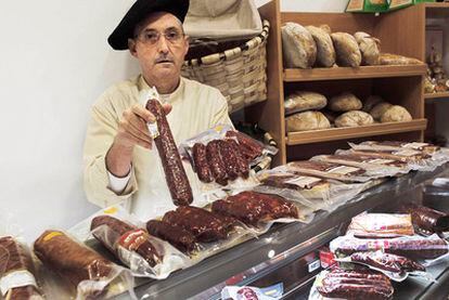 Xoán Quinteiro, vendedor de productos autóctonos en el casco histórico de Santiago, tras el mostrador de embutidos gallegos.