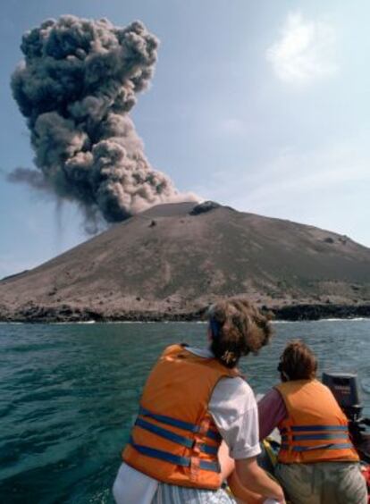 Turistas observando desde un barca una pequeña erupción del volcán Anak Krakatau, en Indonesia.