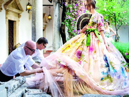 Domenico Dolce y Stefano Gabbana terminan uno de los vestidos de su primer desfile de Alta Moda, que tuvo lugar en Taormina en 2012.