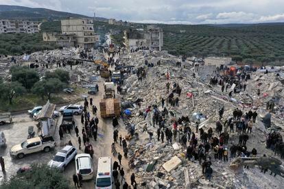 Equipos de rescate, dotados de maquinaria pesada, buscan víctimas entre los escombros de varios edificios derruidos en Idlib, Siria.