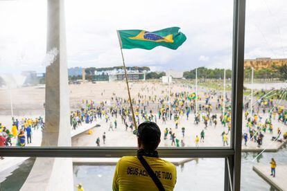 Un hombre con una bandera brasileña se manifiesta contra Lula en Planalto este domingo durante la toma a varias instituciones por parte de seguidores de Bolsonaro.
