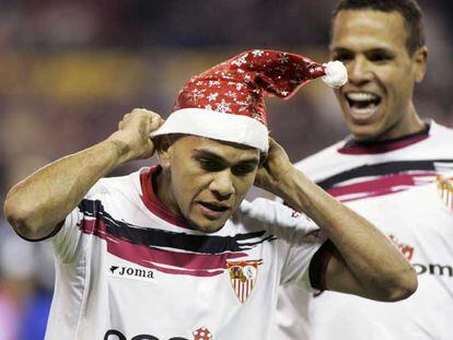 Alves se coloca un gorro de Navidad antes de ser felicitado por Luis Fabiano.