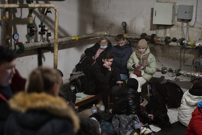 Varias personas permanecen en un refugio en el sótano de un edificio mientras las sirenas anuncian nuevos ataques rusos en Kiev.