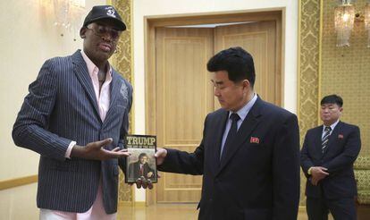 Dennis Rodman entrega un ejemplar del libro de Trump al ministro norcoreano de Deporte, Kim Il Guk Thursday.