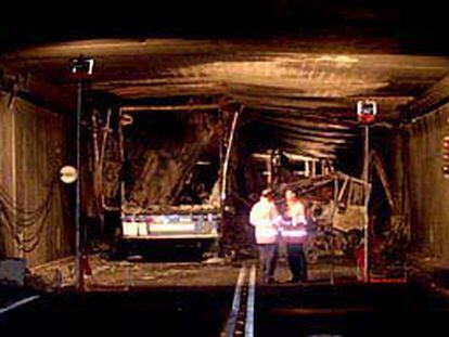 Dos miembros de los equipos de rescate cambian impresiones en el interior del túnel de San Gotardo.