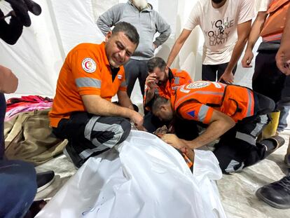 Trabajadores de emergencias gazatíes lloraban ante el cadáver de un compañero, muerto por un bombardeo israelí sobre la franja de Gaza. 