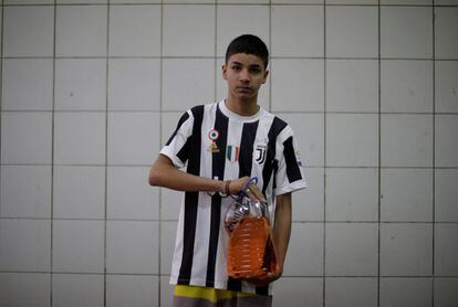 Paulo Henrique, de 15 años, posa con un bidón de gasolina que rellenó para su padre, que necesita ir al hospital. 