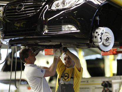 Dos operarios trabajan en una cadena de montaje de la automovilística Opel, en Ruesselsheim.