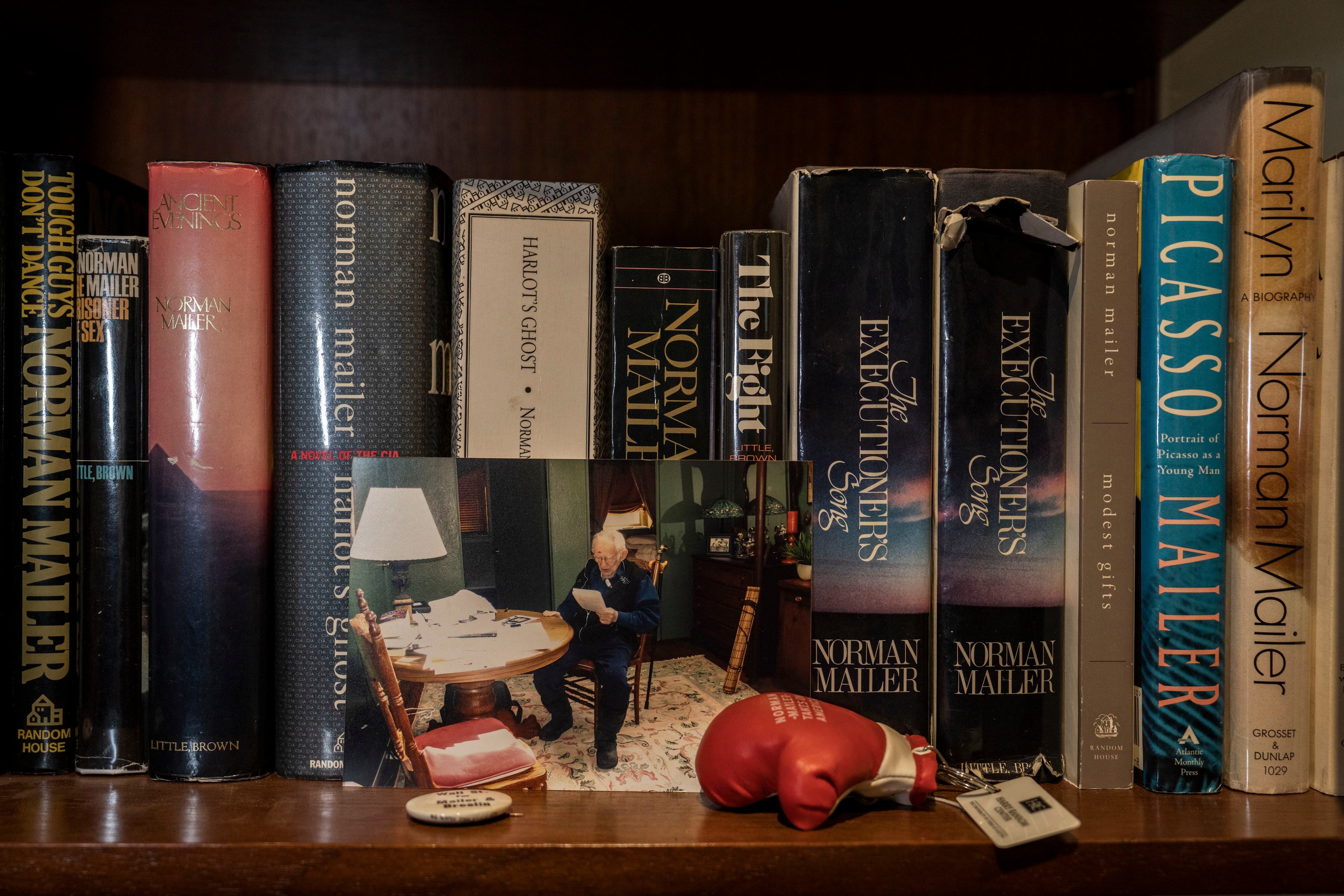 Susan Mailer encargó un mueble para las primeras ediciones de los libros de su padre y lo instaló en su piso de Santiago de Chile. Junto a los volúmenes, una foto del escritor y uno de sus guantes de boxeo.