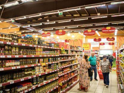 Varios consumidores compran alimentos en un supermercado. 