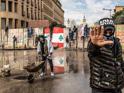 Varios manifestantes intentan traspasar el 11 de febrero los muros de hormigón levantados para impedir el acceso de civiles al Parlamento libanés en Beirut.