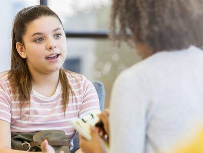 Una orientadora atiende a una alumna adolescente.