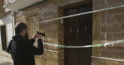 Un hombre fotografía la entrada a la vivienda de La Victoria (Córdoba) donde fue hallado el cadáver de una mujer.