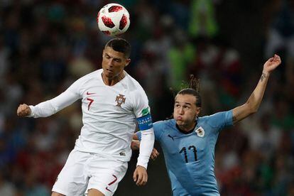 Cristiano Ronaldo (i) golpea el esférico ante la presión de Diego Laxalt.