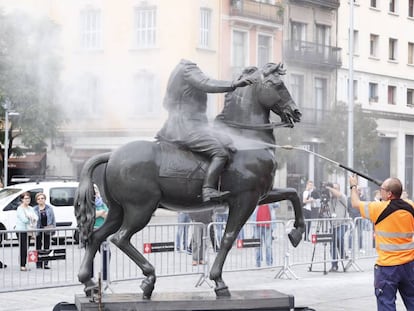 Uns operaris netegen l'estàtua de Franco decapitat, després que li hagin llançat ous.