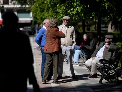 Un grupo de personas mayores conversando en un parque en Sevilla.