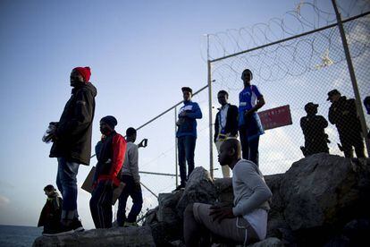 Varios jóvenes tras la valla que separa Ceuta de Marruecos donde cayó herido el chico de 16 años. 